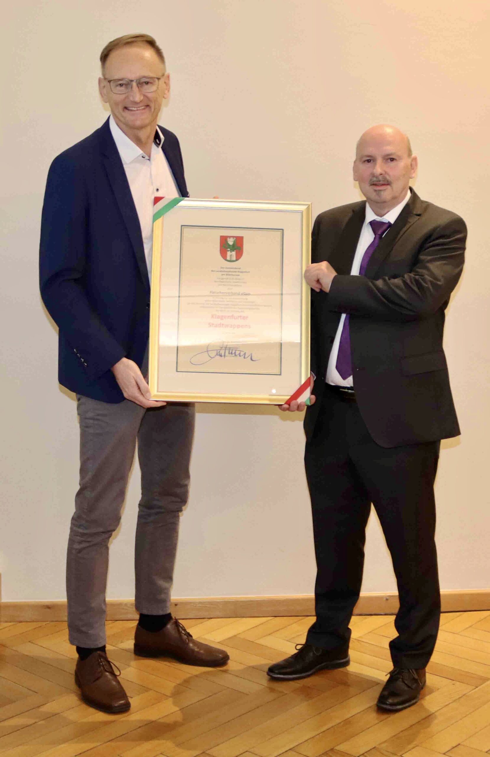 Geschäftsführer Mag. Wolfgang Hartl und Filialleiter Norbert Zimpernig (r.) freuten sich, das Klagenfurter Stadtwappen entgegenzunehmen.