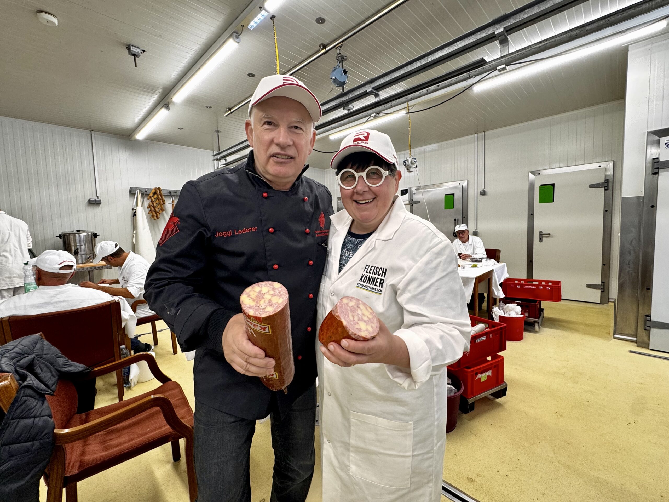 Gut gelaunt bei der Verkostung: Doris Steiner-Bernscherer, stellvertretende Oberjurorin, und Jogi Lederer mit einer Käsewurst. Lederer zeigte sich begeistert: „Es gab sehr viele Produkte mit Käse – das hat mir als Käseliebhaber natürlich gefallen.“ (Bild: Fleisch & Co/Braune)